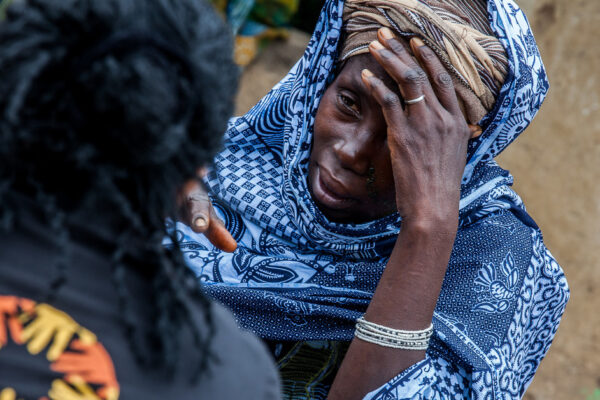 Fatmata Saccoh speaks with a CARE aid worker in Mannah.